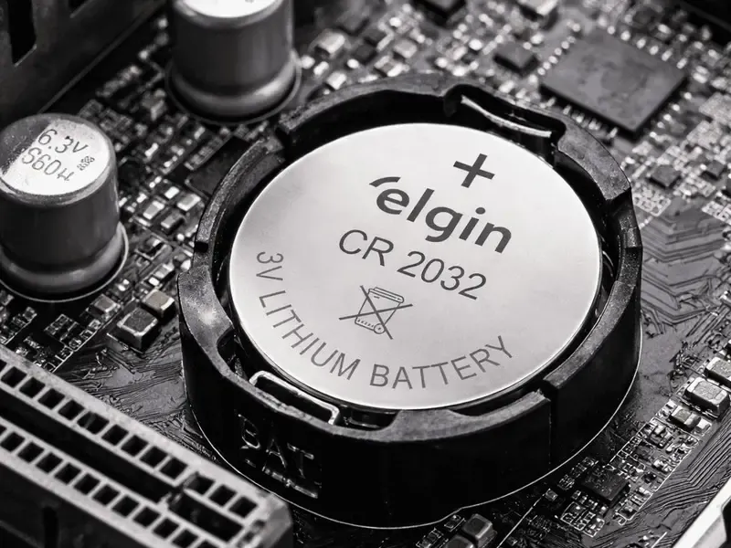 Bateria redonda CR2032 de 3 V encaixada no soquete da placa-mãe.